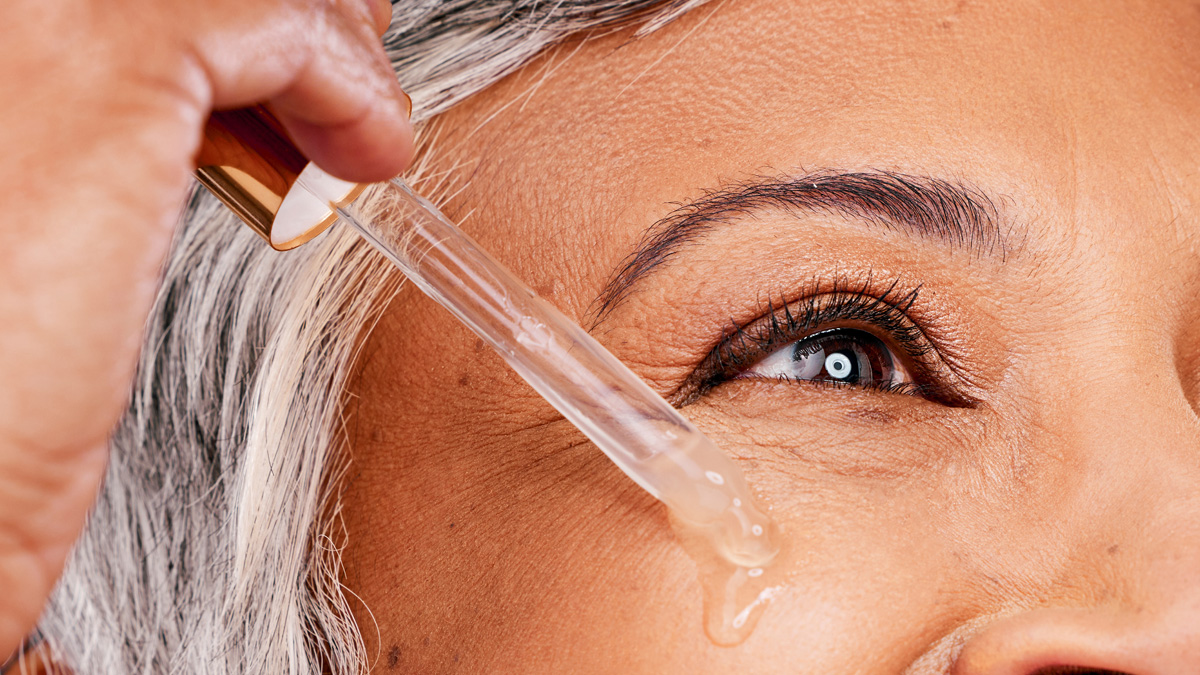 vrouw brengt serum met retinol aan op gezicht